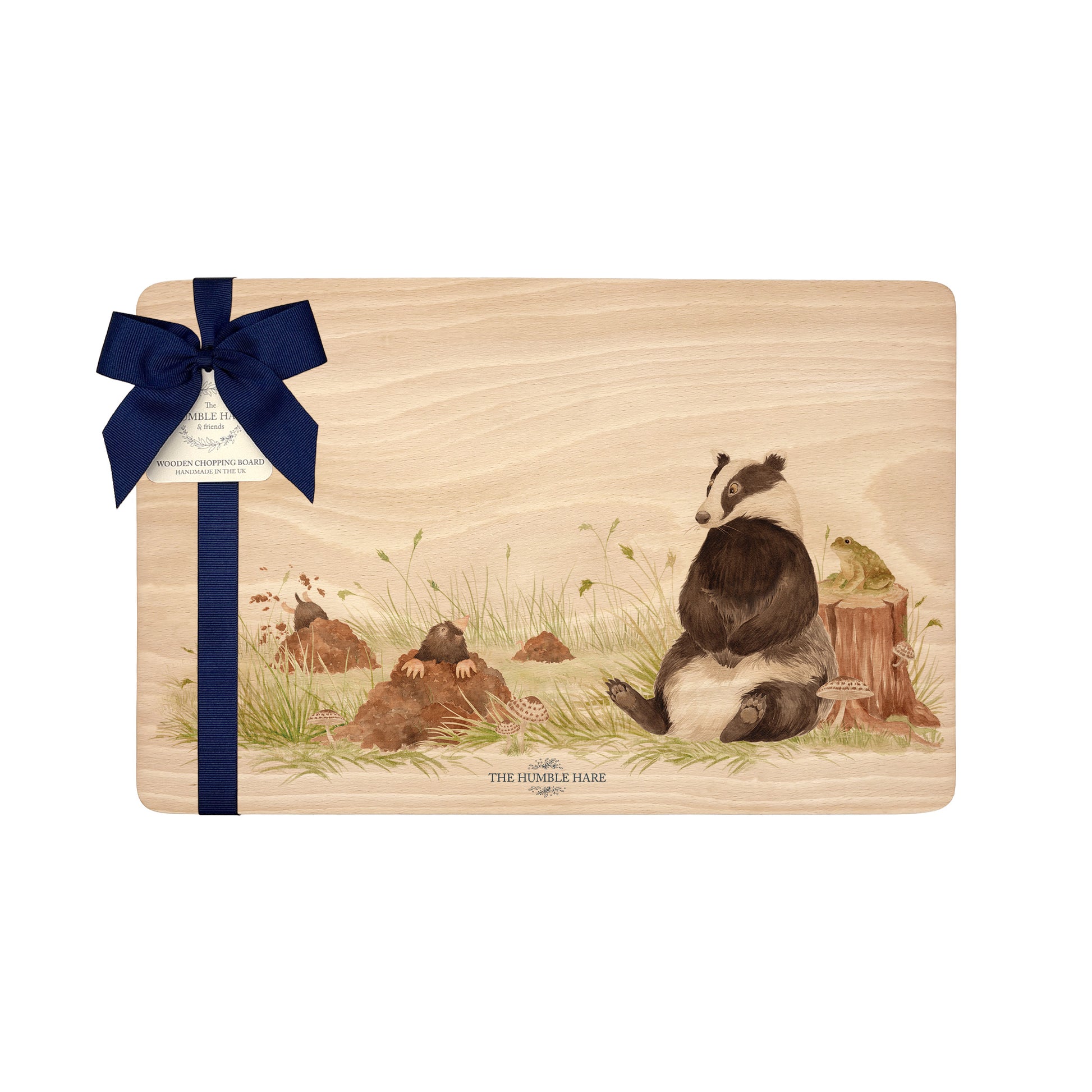Rectangle beech wood chopping board featuring a watercolour design of a badger, mole and toad in the woodland. The wooden board is finished with a blue gift ribbon and tag.