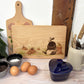 Rectangle wooden chopping board on a kitchen worktop. The beech wood board features a watercolour design of a badger, mole and toad in the woodland.