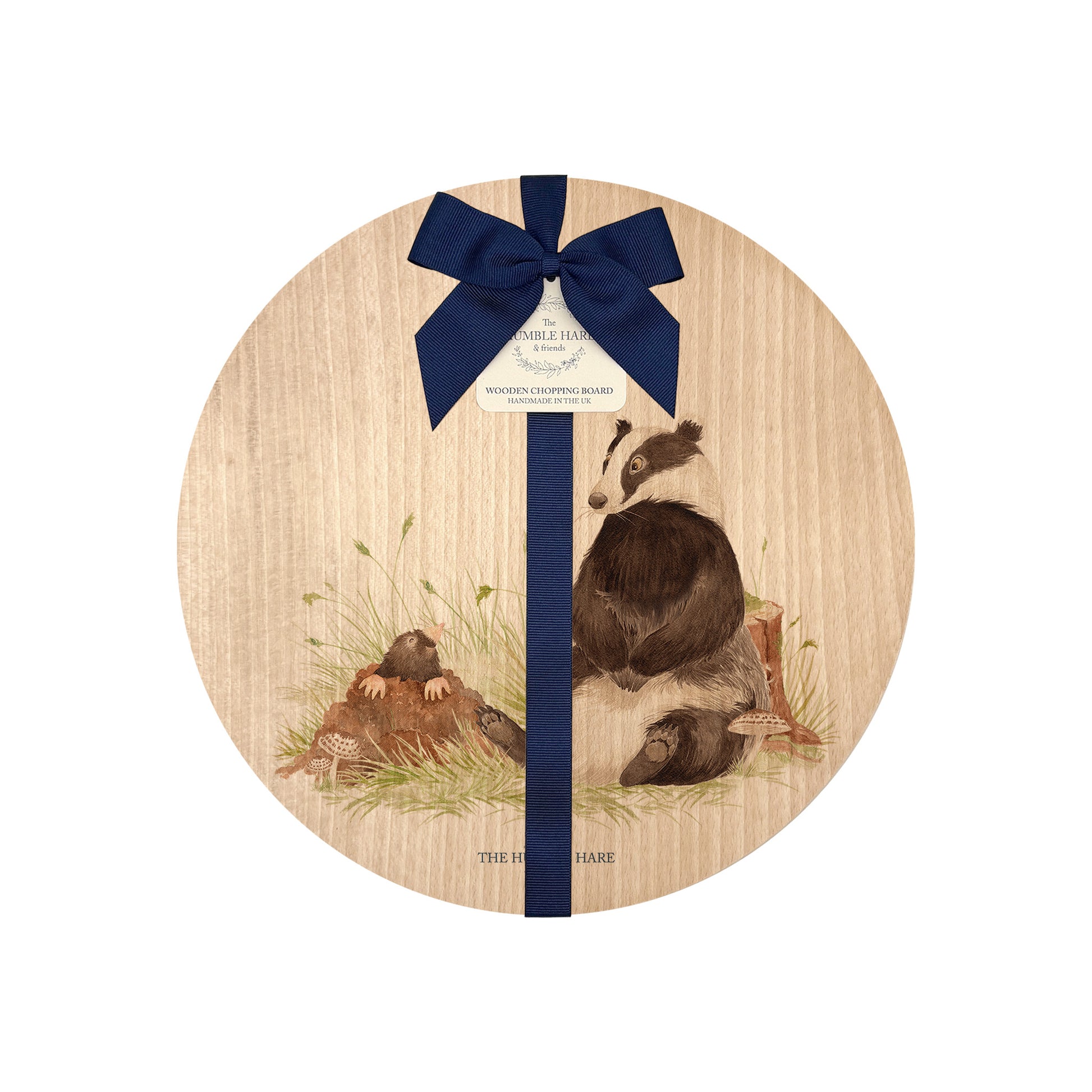 Round beech wood chopping board featuring a badger and mole woodland animal design. The wooden board is finished with a blue gift ribbon and tag.