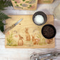 Rectangle wooden chopping board on a kitchen worktop. The beech wood board features our blooming bunnies woodland animal design, with rabbits among spring flowers.