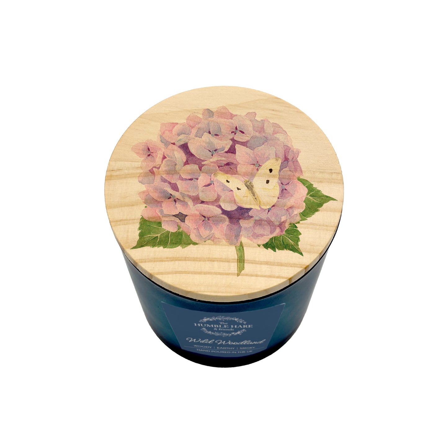 A dark blue jar candle with a light wood lid decorated with a pink hydrangea and a cream butterfly, shown on a white background.