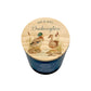A personalized scented candle in a dark blue cylindrical tin with a light wood lid printed with a duck illustration and the text 'MR & MRS Duckington'.