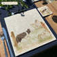 A square large marble platter with a design of a border collie working dog herding sheep through a gate on the farm. The platter is set on a wooden country kitchen table.