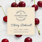 A square cream-colored label for The Humble Hare's Cherry Bakewell scented candle surrounded by fresh red cherries on a white textured background.