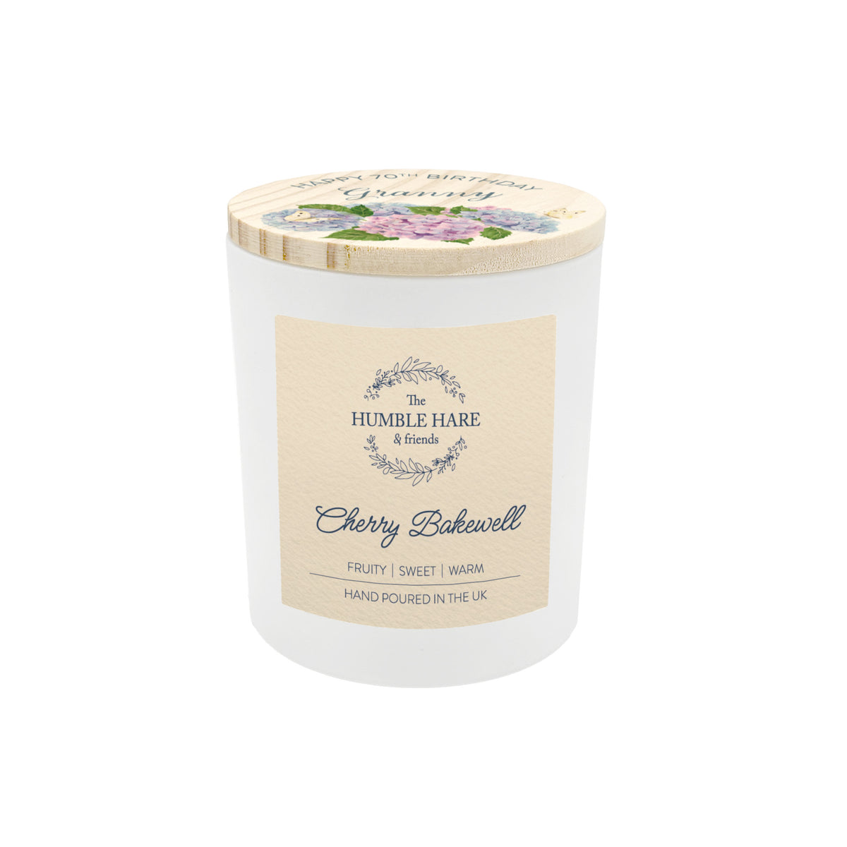 A white glass jar candle with a light wood lid decorated with watercolour illustrations and personalised text.