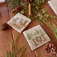 A set of mix and match marble coasters featuring different Christmas designs including a donkey nativity scene and a winter forest scene with a cottage and mice on a gate with a Christmas wreath