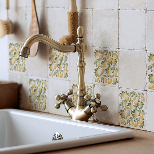 A rustic kitchen sink with a splash back made up of 10x10cm marble tiles with a watercolour pattern of Mediterranean lemons and leaves.