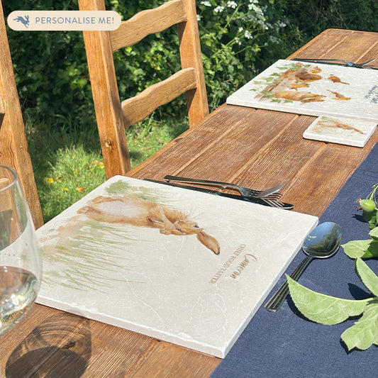 A beautiful garden table set with personalised marble placemats and coasters, ready for a dinner party. The placemats feature countryside animals with personalised names above them.