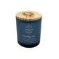 A dark blue glass jar candle with a light wood lid decorated with a sheep wearing a Christmas wreath illustration. The front features a blue label with white text that reads 'HUMBLE HARE & FRIENDS' and 'Crackling Fire'.