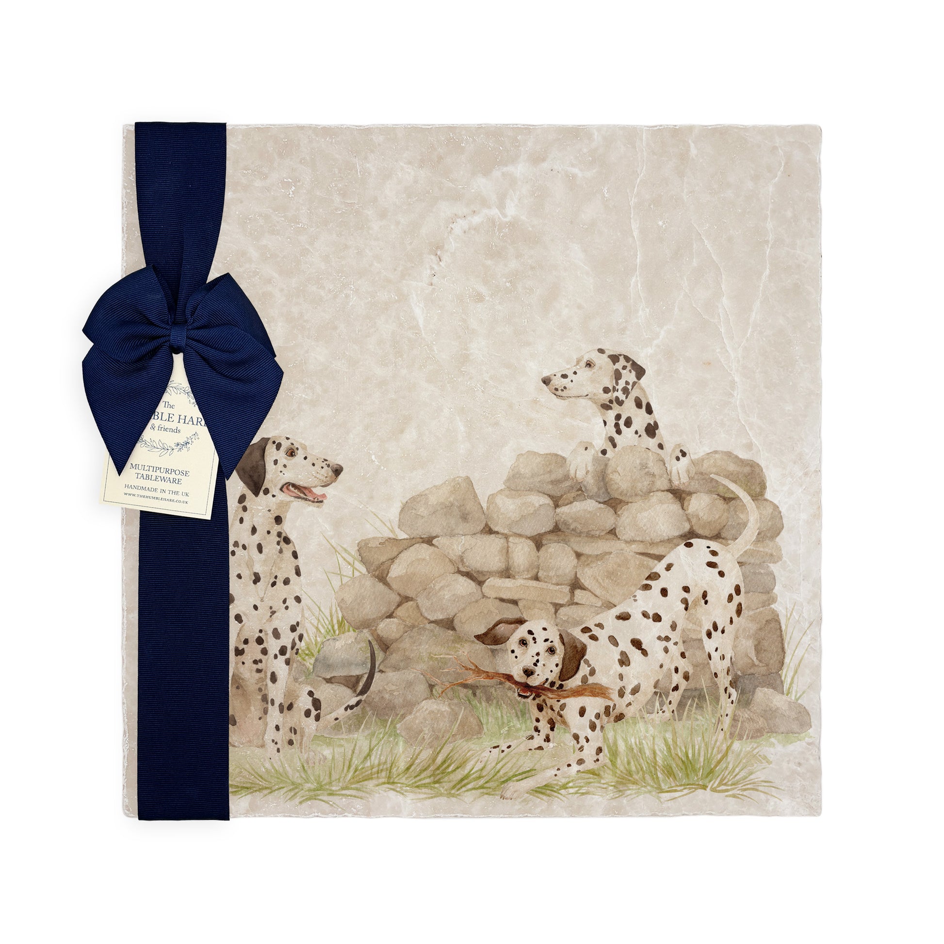 A large square marble platter featuring a  watercolour design of 3 dalmatian dogs playing fetch in the countryside. The platter is packaged with a luxurious blue gift bow.