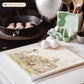 A large square marble platter featuring a  watercolour design of 3 dalmatian dogs playing fetch in the countryside. The platter is sat next to a stove top in the kitchen.