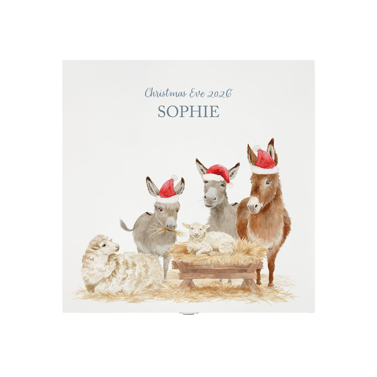 The top of a white wooden Christmas Eve gift box with a donkey away in a manger watercolour illustration, the box is personalised with a name