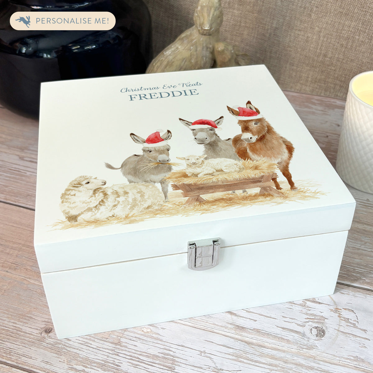 A white wooden Christmas Eve gift box with a donkey away in a manger watercolour illustration, the box is personalised with a name