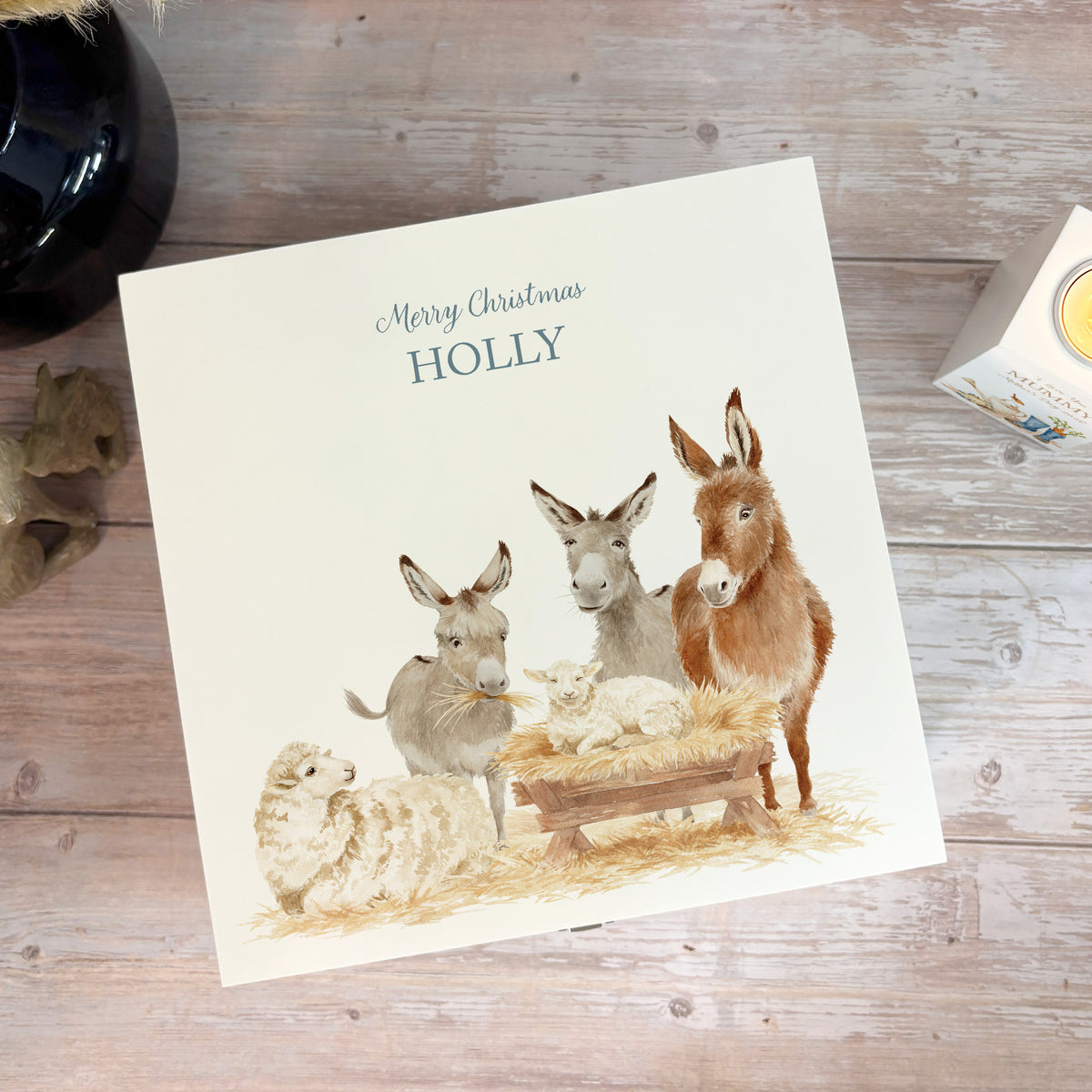 A white wooden Christmas Eve gift box with a donkey away in a manger watercolour illustration, the box is personalised with a name