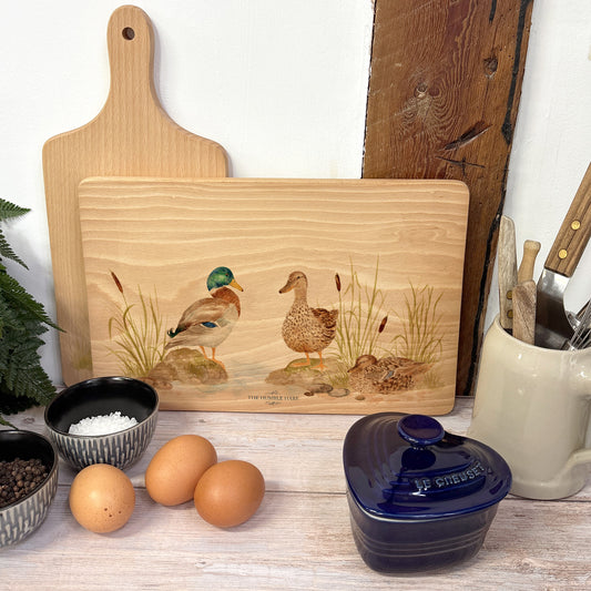 Handmade rectangular chopping board featuring a watercolour Mallard Ducks  illustration, finished with blue ribbon.
