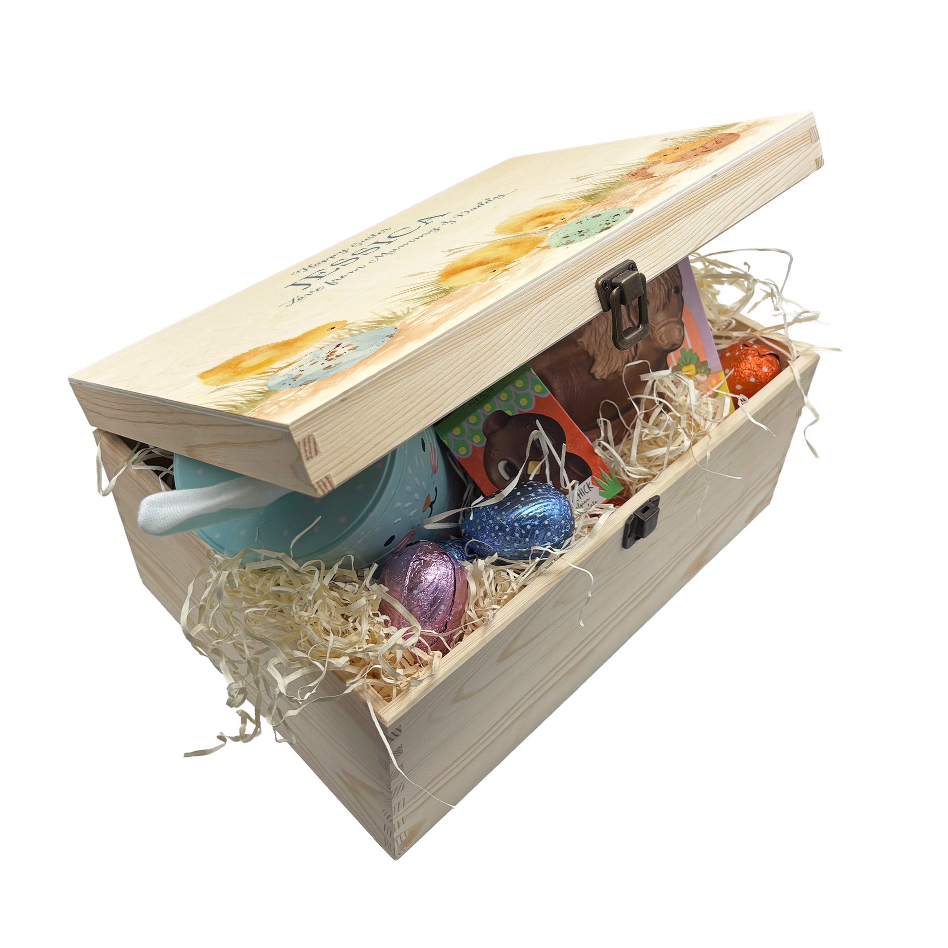 This wooden keepsake box is a large Easter box, perfect for creating a box full of Easter eggs and treats. The box is great for storing keepsakes in once the Easter treats have been eaten. This design has 4 chicks, one has a chick that has just hatched and the other 3 are looking at the pastel colour easter eggs on the floor  wondering if any more chicks may hatch or not. This gift box is perfect for filling with lots of easter treats. This box is filled with easter chocolate treats and biscuits 