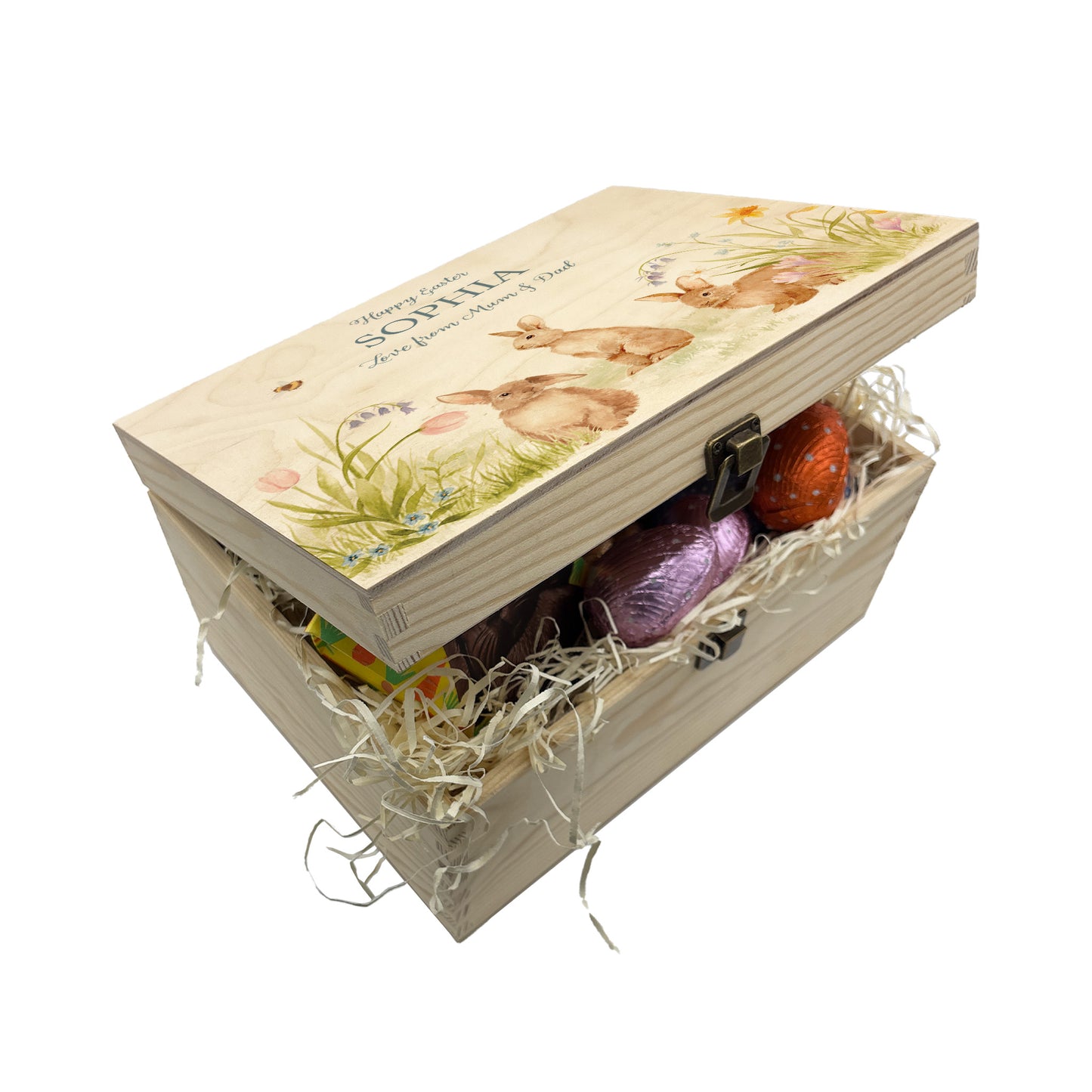 Small Easter personalised wooden pine box, perfect for Easter treats, eggs, gifting. Children gifts. This box has a beautiful easter theme with 3 bunnies surrounded by some spring flowers and some bees. This box can be personalised in 4 phrases or it can just have the design and no text. What better way to surprise your friend, parent, teacher or child with a unique personalised keepsake easter box. This box shows a great example of how to fill your easter box with treats 