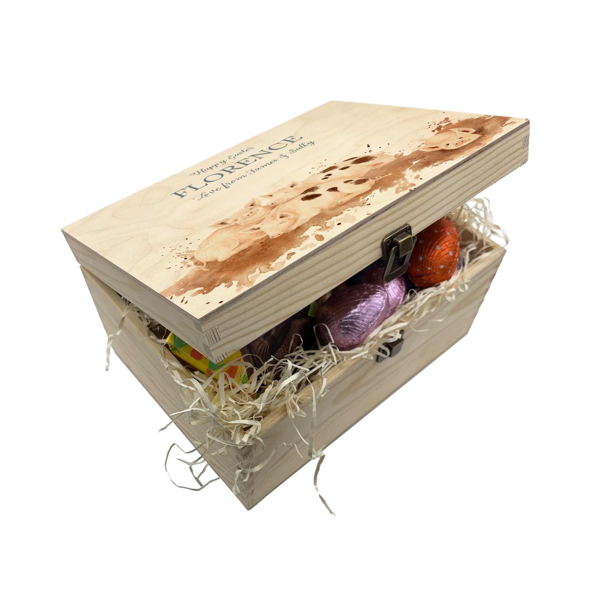 Small Easter personalised wooden pine box which has an antique clasp perfect for Easter treats, eggs, gifting. Children gifts. This box has a beautiful easter theme with 4 piglets rolling around in mud. This box can be personalised in 4 phrases or it can just have the design and no text. The Ester box is full with lots of chocolate easters eggs and biscuits perfect for gifting.