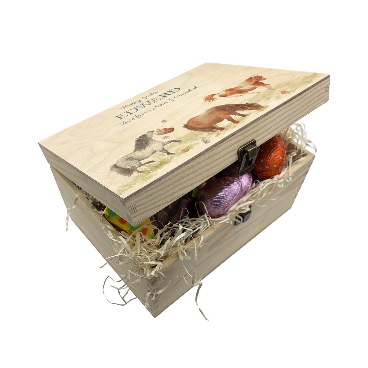 This Easter medium wooden gift box box has 3 Shetland ponies running around a spring meadow. One Shetland is swinging a bucket full of pastel easter eggs which has flung all over the meadow. another is bucking and having lots of fun another is grazing and the other is stood watching. These easter boxes are great for gifting and filling full of easter treats for your loved ones, children, parents and friends. Great keeps sake to keep.  This box is displayed showing lots of yummy easter treats, chocolates 