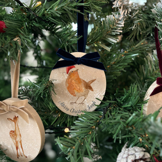 Add an elegant touch to your festive décor with our handcrafted oval-shaped marble baubles. Featuring beautiful watercolour designs of countryside animals and finished with a velvet ribbon in your choice of colour, these baubles can be personalised to reflect your unique style.