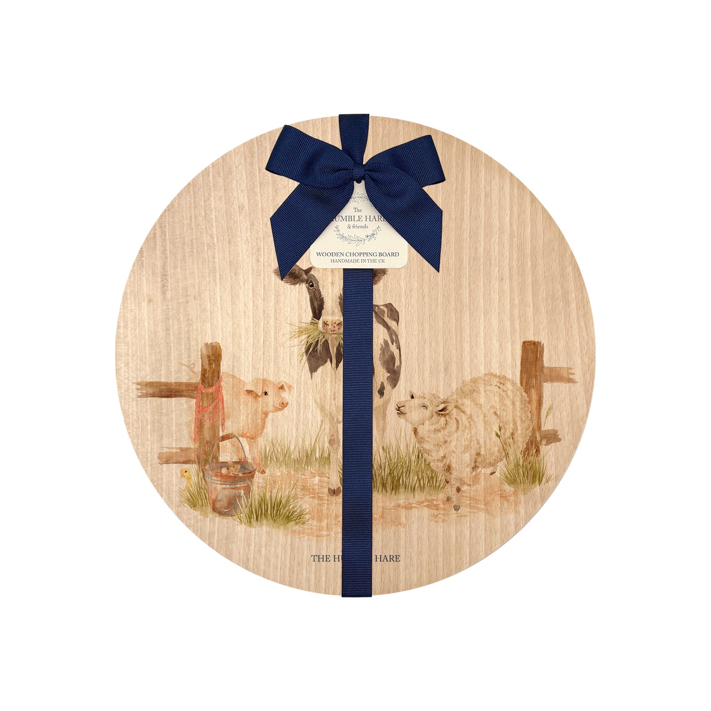 Round beech wood chopping board featuring full of farm animals, including the dairy cow, grazing horse, sheep, piglets, ducklings and chicken. The wooden board is finished with a blue gift ribbon and tag.