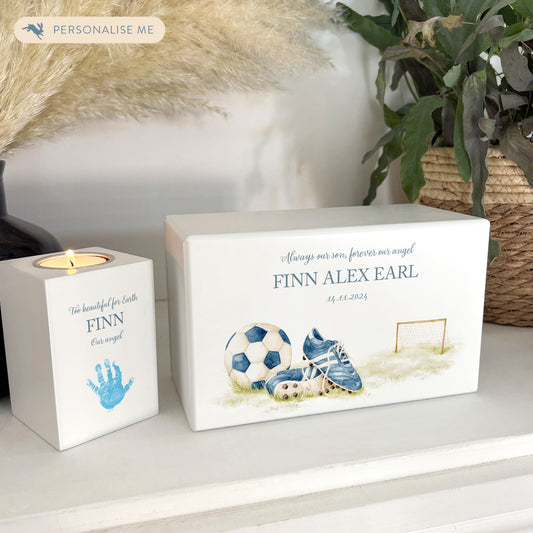 A beautifully crafted solid wooden urn, finished in white with a soft watercolour design of football boots and ball. Thoughtfully made for either display or burial, this personalised urn can be customised to create a meaningful memorial. Perfect for holding ashes of a loved one or a beloved pet, it serves as a comforting tribute and keepsake.