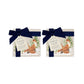 Set of four square marble coasters featuring a winter forest illustration with a fox family and evergreen trees in the snow. The coasters are bowed in two pairs with a navy blue ribbon.