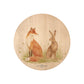 Round beech wood chopping board featuring a watercolour design of a fox and hare in a meadow.