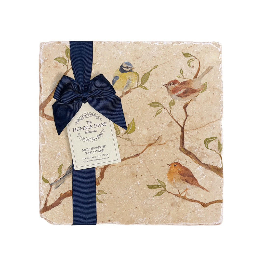 A medium multipurpose marble platter with a British garden birds on branches design, packaged with a luxurious dark blue bow and branded gift tag.