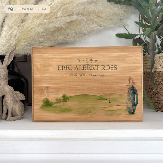 A beautifully crafted solid Bamboo wooden urn, personalised and finished with a soft watercolour design of a golf bag and green, Perfect for the golf lover- Great for Dad, Grandad, Brother, Son, Uncle.  Thoughtfully made for either display or burial, this personalised urn can be customised to create a meaningful memorial. Perfect for holding ashes of a loved one or a beloved pet, it serves as a comforting tribute and keepsake. 