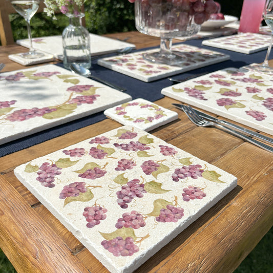 A square medium multipurpose marble platter used as a side plate on a garden table. The platter features a maximalist grape vine pattern.