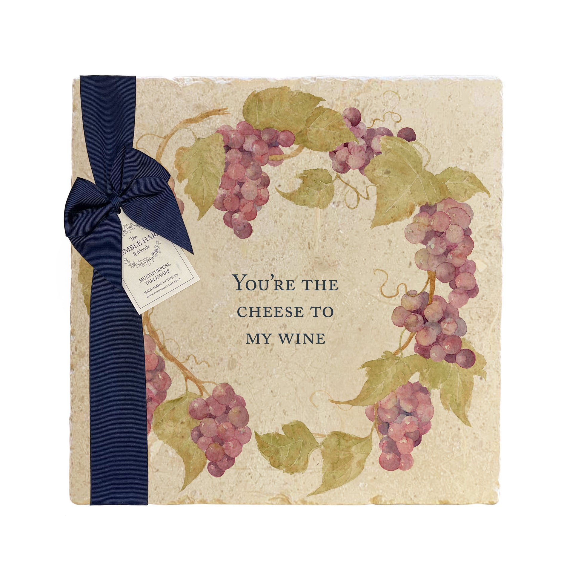 A personalised marble platter featuring a wreath of grape vines and leaves, with a bespoke message in the centre of the design. The platter is packaged with a luxurious blue gift bow and tag.