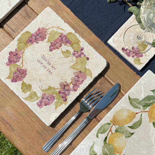 A medium marble serving board personalised with the bespoke message You’re My Cup of Tea’. The serving board is set on a table in a sunny garden.