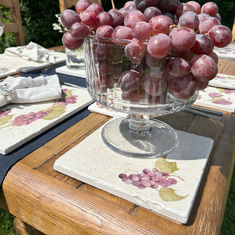 A minimalistic medium square marble serving board that features a watercolour design of a single bunch of grapes.