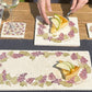 A medium square marble platter featuring a watercolour grape vine wreath design. The platter is being used to serve a fruit tart.