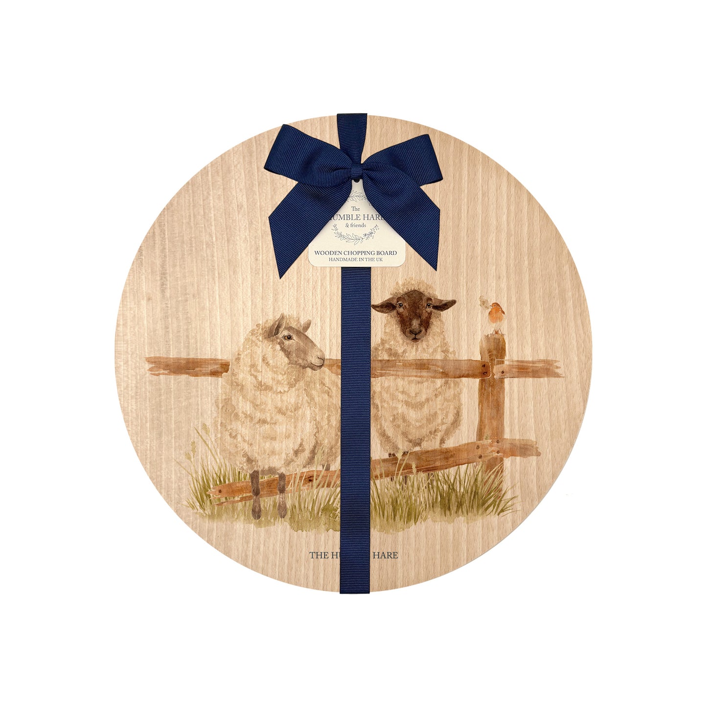 Round beech wood chopping board featuring a watercolour design of mischievous sheep escaping their field. The wooden board is finished with a blue gift ribbon and tag.