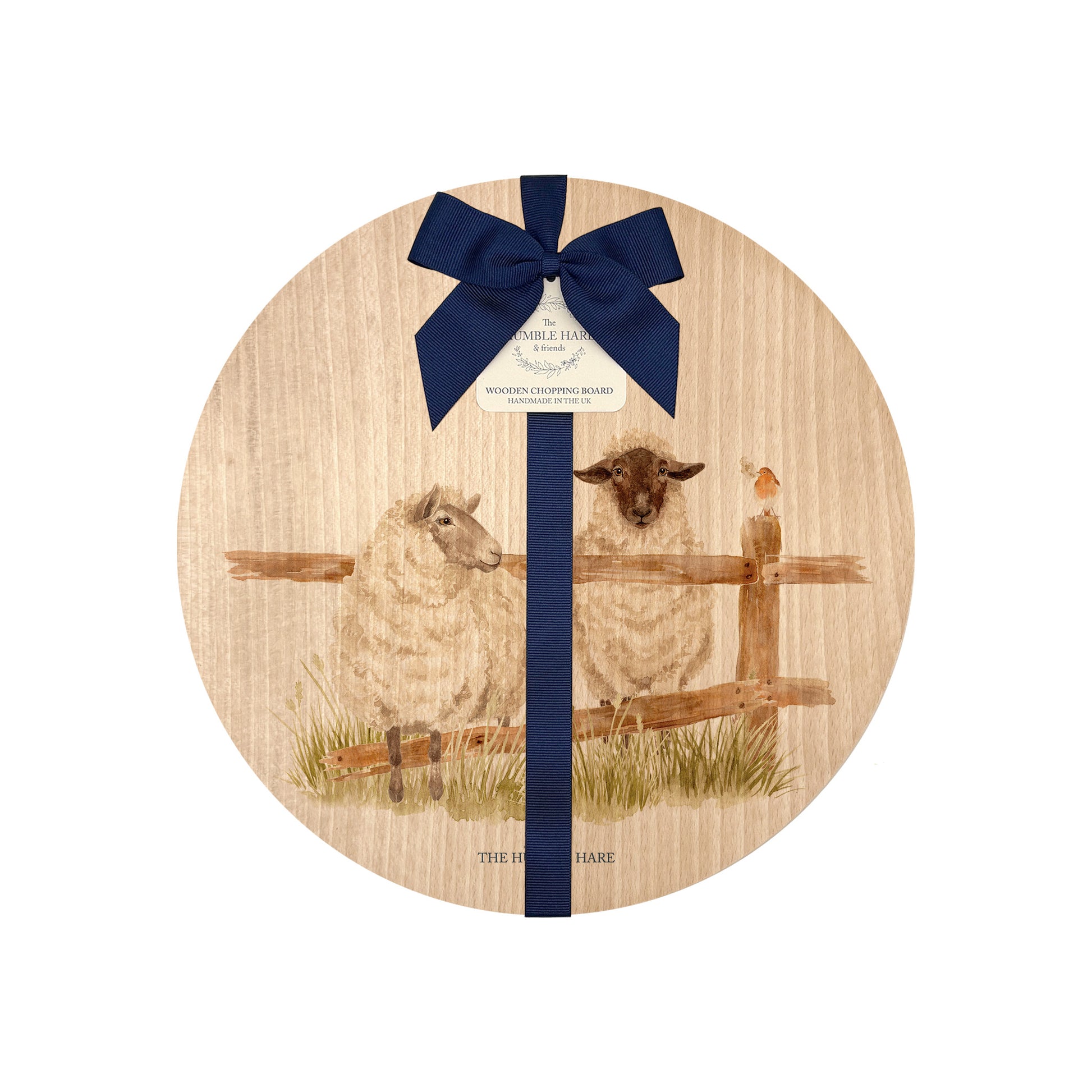 Round beech wood chopping board featuring a watercolour design of mischievous sheep escaping their field. The wooden board is finished with a blue gift ribbon and tag.