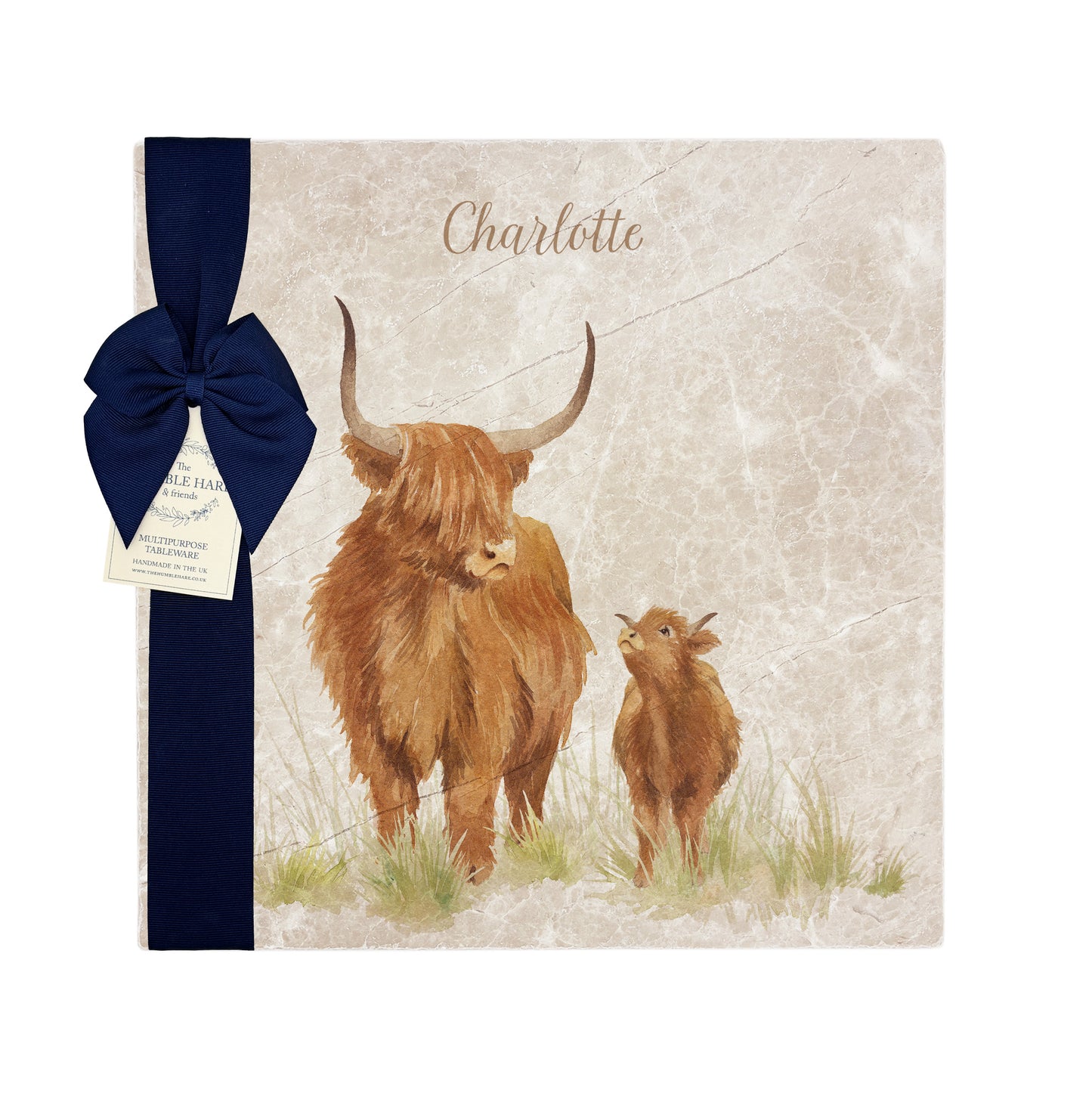 A large square personalised marble placemat with a highland cow and calf design. The placemat is packaged with a luxurious dark blue ribbon and The Humble Hare branded tag.