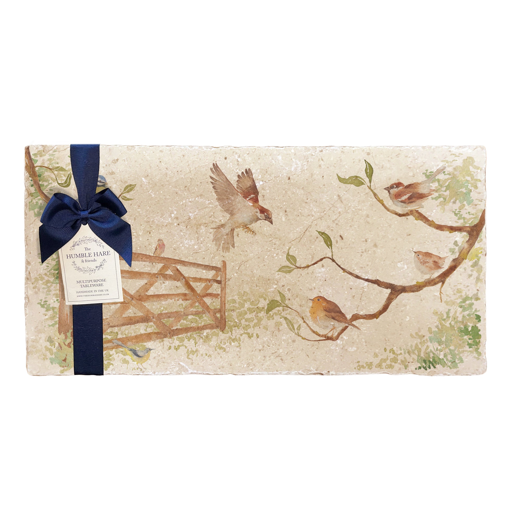 A multipurpose marble platter with a watercolour design featuring British garden birds in the hedgerow around the paddock gate, packaged with a luxurious dark blue bow and branded gift tag.