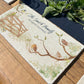 A marble sharing platter personalised with a family surname and house name in dark blue text. The platter features a watercolour design of garden birds in the hedgerow around a gate.