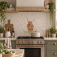 British countryside marble mural above a traditional range cooker, featuring a highland cow 