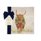 A square medium marble platter featuring a watercolour illustration of a Highland cow with a Christmas wreath around his neck. The platter is wrapped with a navy blue bow and paper tag.