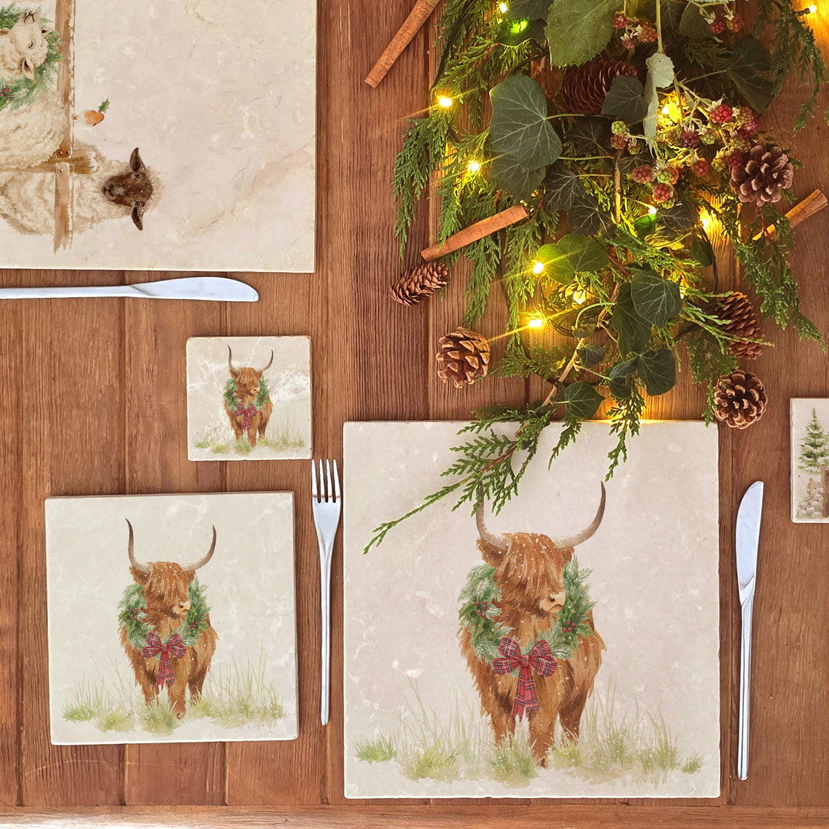A square medium marble platter featuring a watercolour illustration of a Highland cow with a Christmas wreath around his neck.