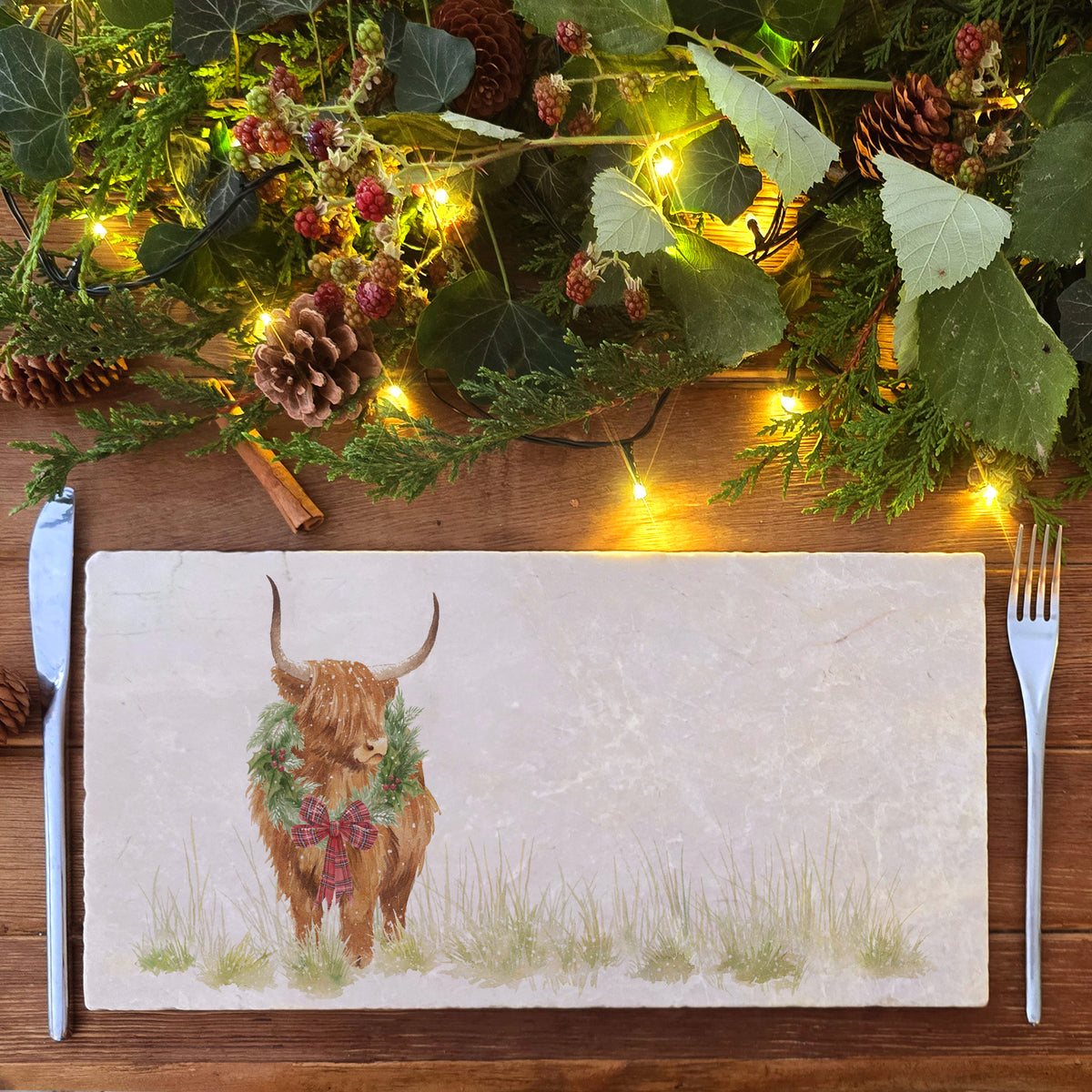 A rectangular marble sharing platter featuring a watercolour highland cow with a Christmas wreath and tartan bow around his neck.