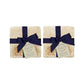 A set of 4 handmade marble coasters packaged in 2 pairs, with a luxurious dark blue bow and gift tag.