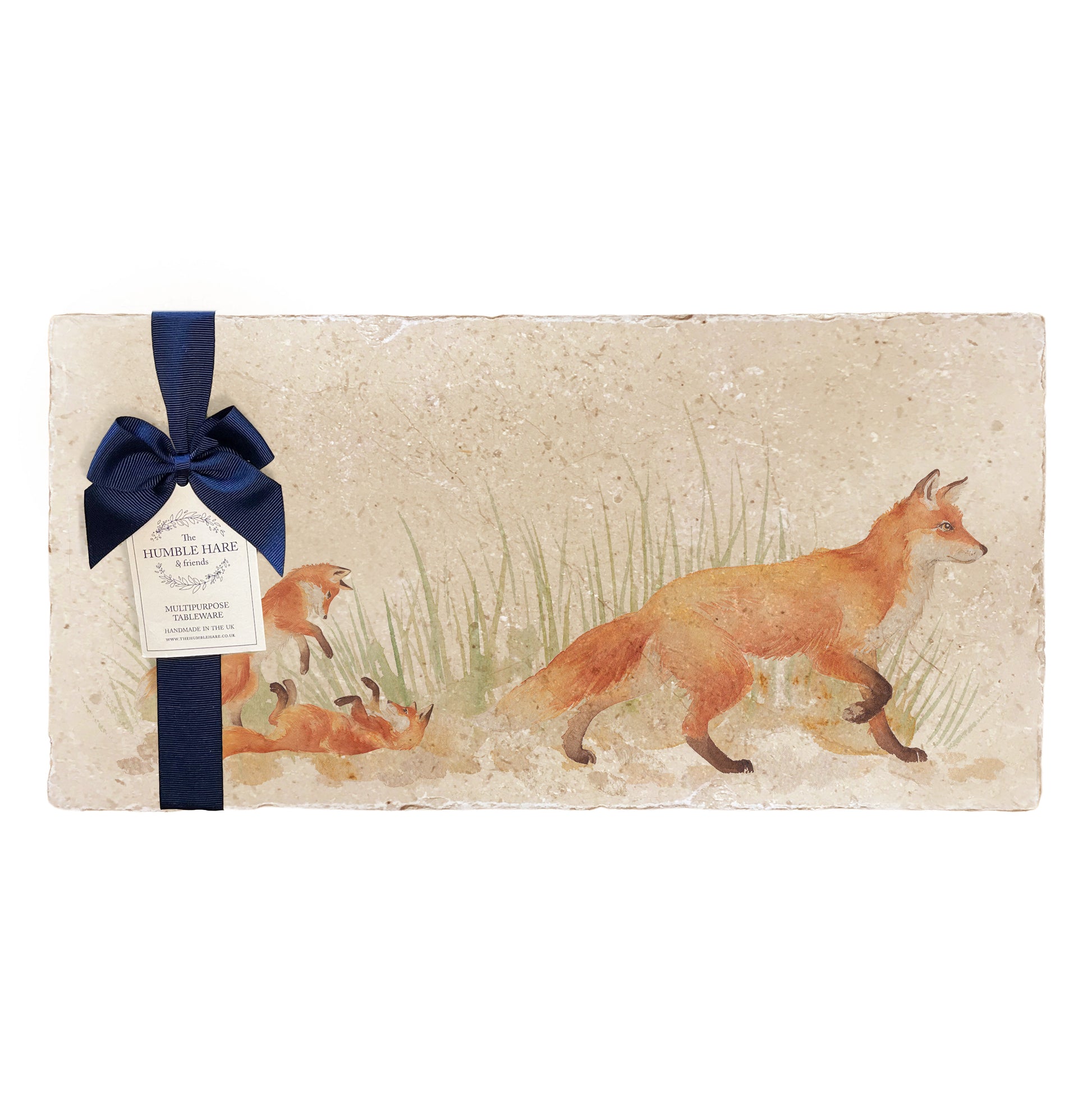 A multipurpose marble sharing platter with a fox and fox cub design, packaged with a luxurious dark blue bow and branded gift tag.