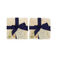 A set of 4 handmade marble coasters packaged in 2 pairs, with a luxurious dark blue bow and gift tag.