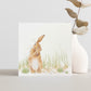 A greetings card featuring a hare washing his ear in a watercolour style.