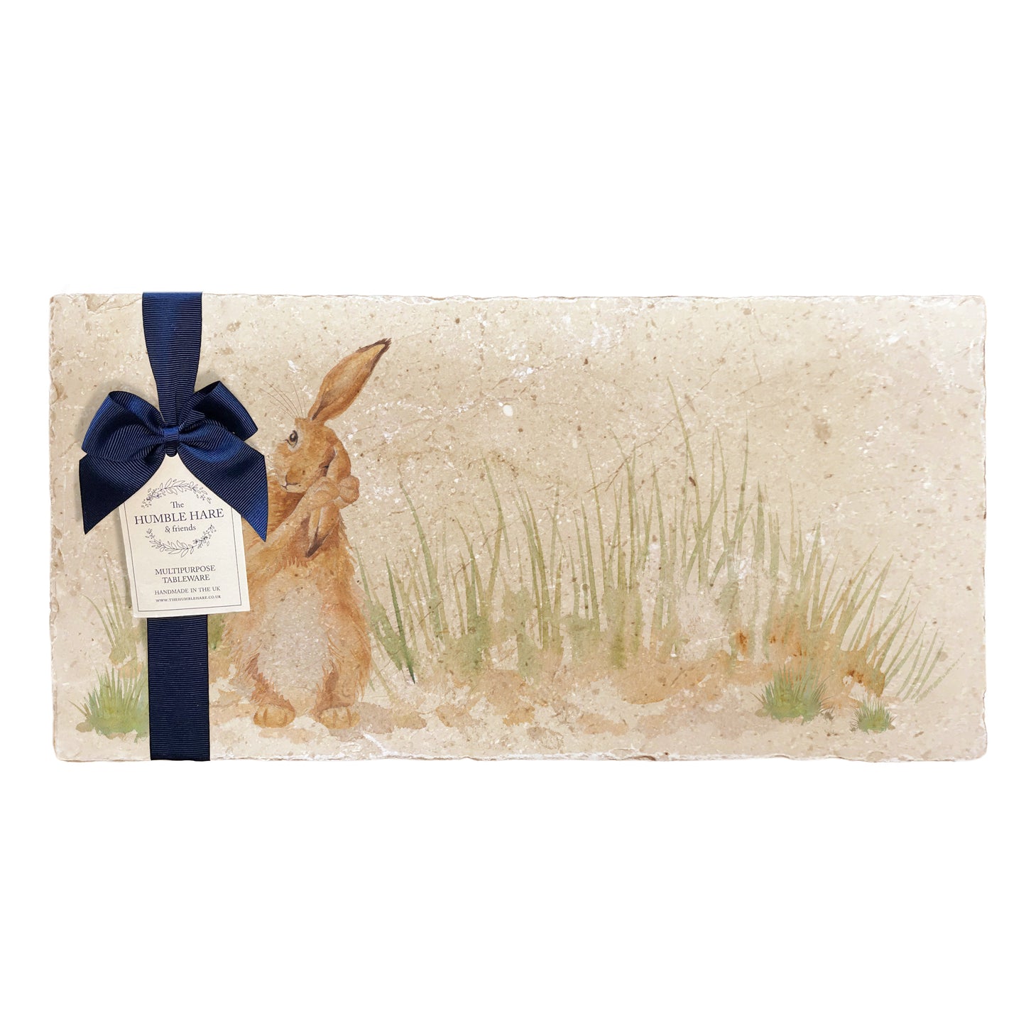 A multipurpose marble platter with a watercolour design featuring a hare washing his ear, packaged with a luxurious dark blue bow and branded gift tag.
