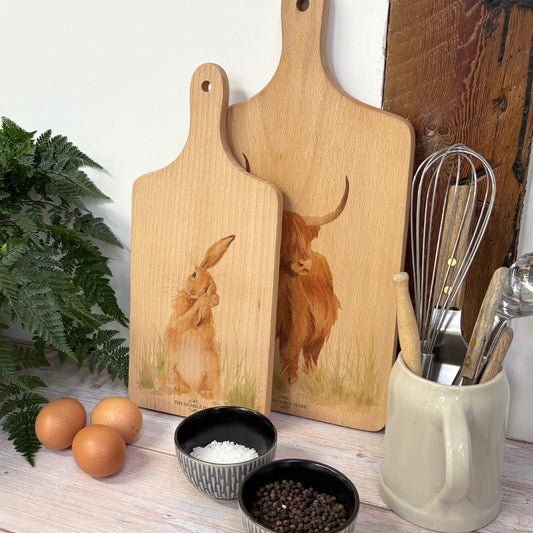 Handmade paddle board in Beech wood, featuring a water colour Hare design with a hand tied luxury blue ribbon. perfect chopping board, charcuterie board, serving board and chopping board. 